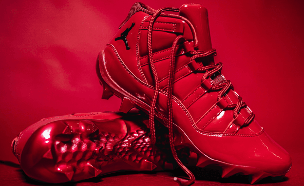 Air Jordan 11 Oklahoma PE in monochrome Sooner red patent leather with metallic red spikes and white OU logo on tongue