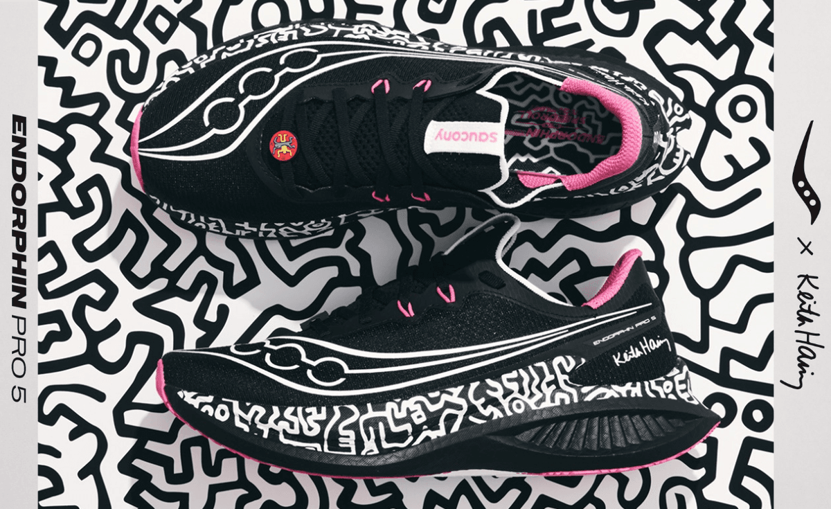 Saucony x Keith Haring Endorphin Pro 5 in black mesh with white dancing figure graphics and pink accents