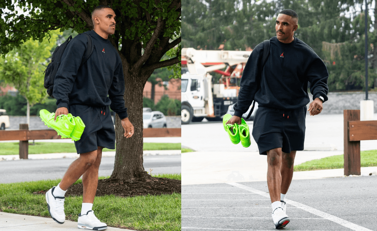 Jalen Hurts wears the Air Jordan 1 Mid TD Kelly Green patent leather cleat at Eagles training camp, a full monochrome design in the team's light green colorway with white Jordan Wings logo on the ankle.