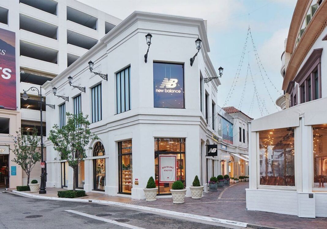 New Balance Los Angeles flagship store interior at The Grove with two-story athlete feature wall and wood paneling design