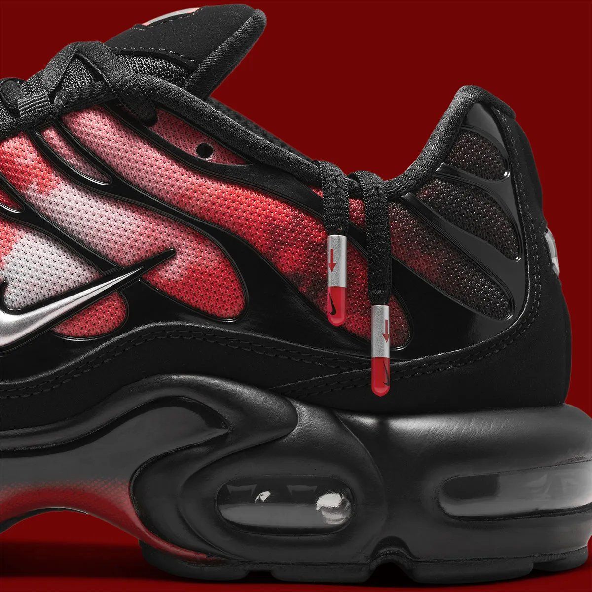Nike Air Max Plus Flairemax in black with red flame graphic, metallic silver Swoosh, and metal lace tips