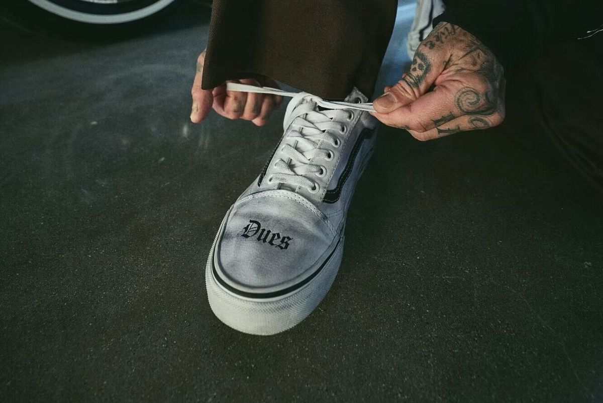 Travis Barker x Vans Old Skool in White and Black colorway, side angle showing classic Old Skool silhouette with collaboration branding
