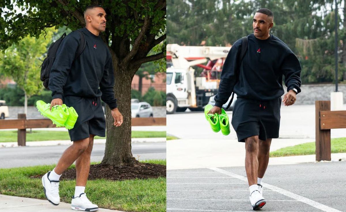 Jalen Hurts wears the Air Jordan 1 Mid TD Kelly Green patent leather cleat at Eagles training camp, a full monochrome design in the team's light green colorway with white Jordan Wings logo on the ankle.