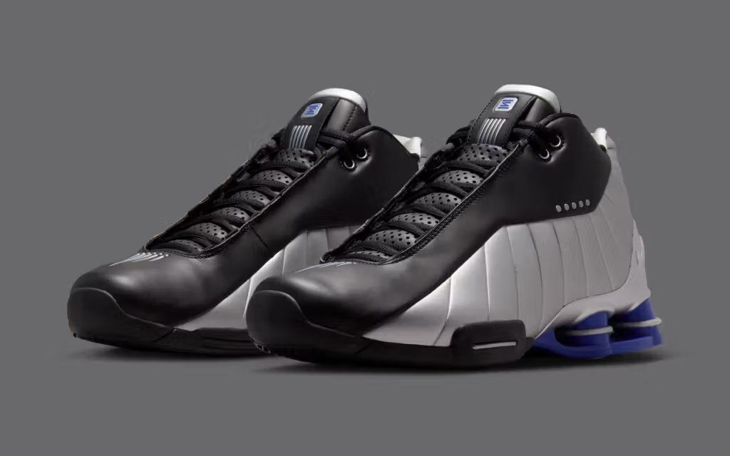 Nike Shox BB4 in Black, Silver, and Lapis colorway, showing the classic Shox column cushioning system and basketball silhouette