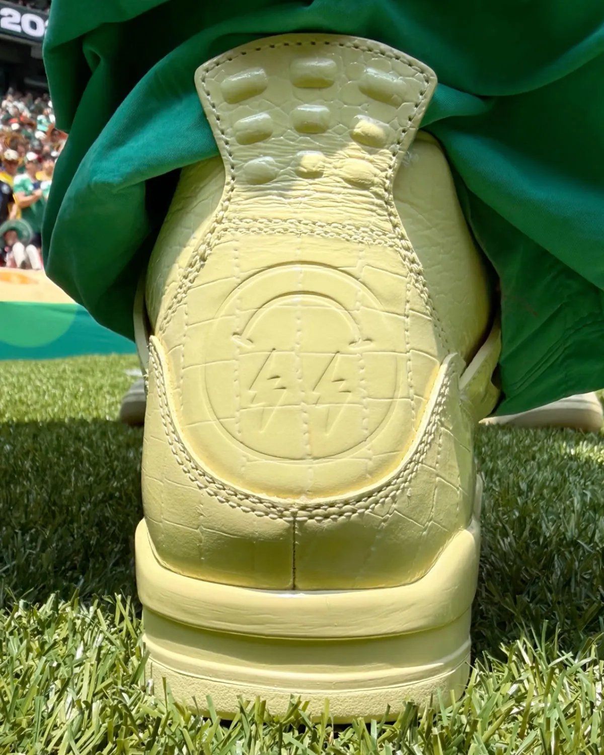 J. Balvin x Air Jordan 4 Lemonade in yellow with croc-textured leather and inverted smiley logo on heel counter