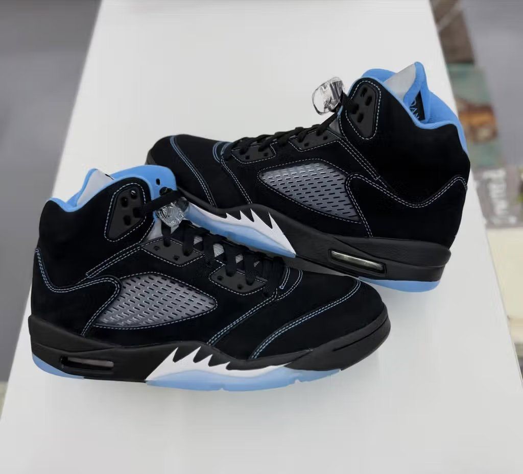 Air Jordan 5 Black/University Blue sneaker, featuring black leather upper with university blue accents on the tongue and midsole detailing