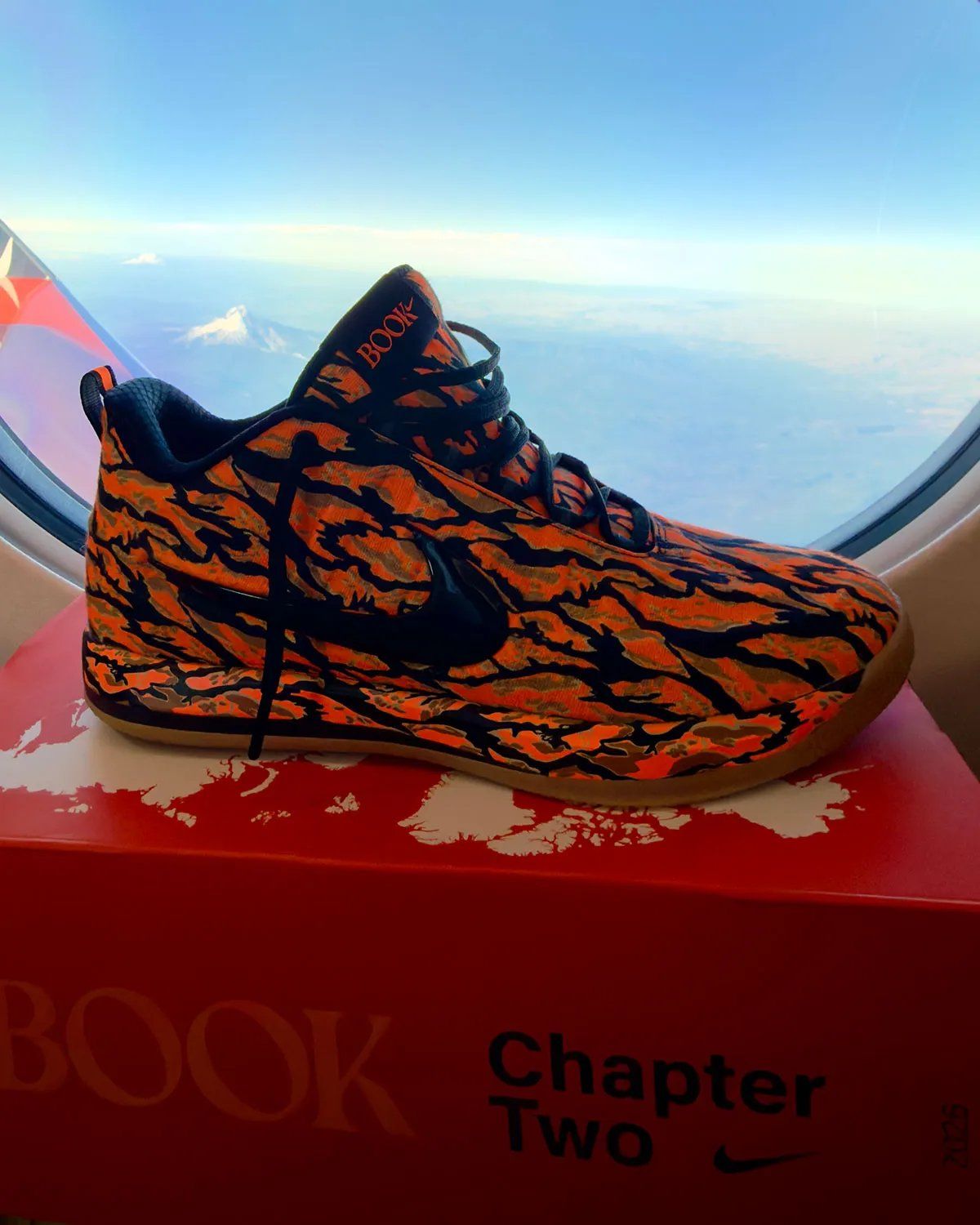 Nike Book 2 Tiger Camo in burnt orange, black, and forest green camouflage pattern across the upper and midsole
