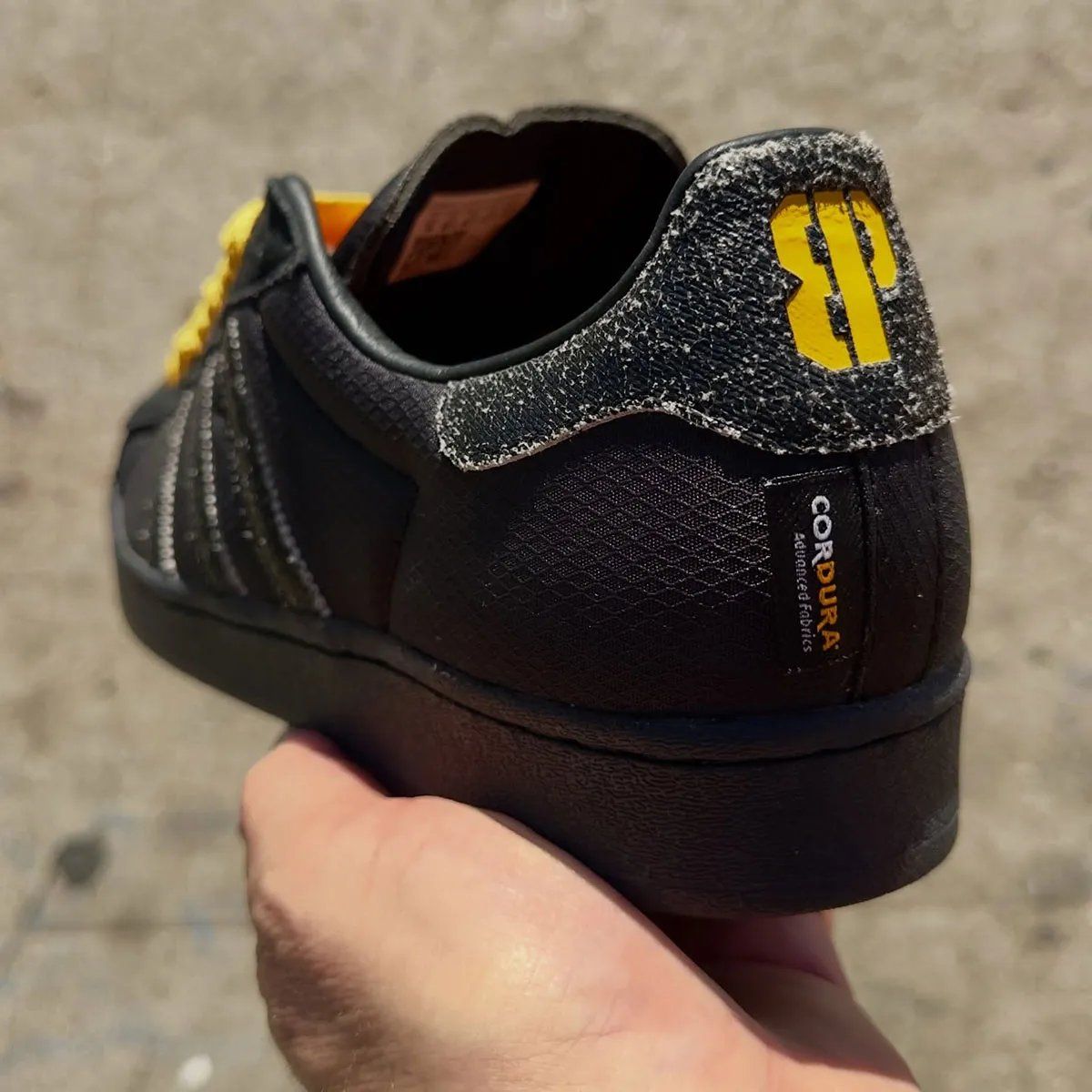 adidas Superstar ADV in all-black with distressed leather detailing, yellow laces, and Cordura construction from the Brooklyn Projects x Anthrax collaboration.
