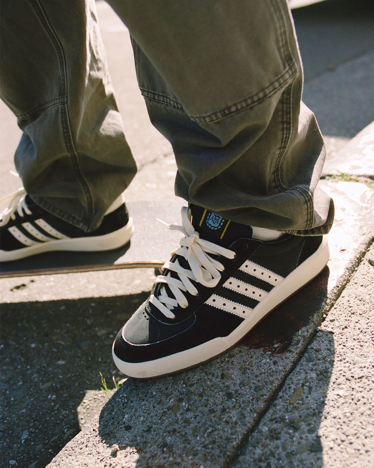 Thrasher x adidas Glenburn Argentina skate shoe in black leather with chalk blue paneling and gold star heel detail