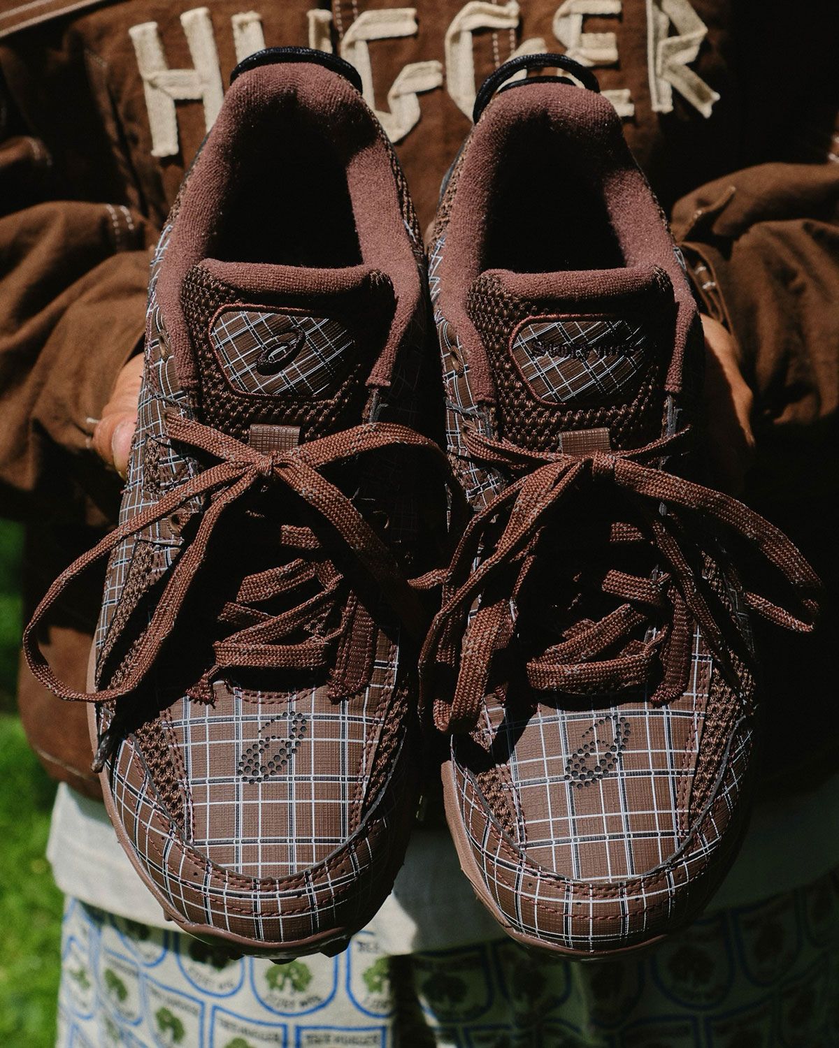 Story mfg. x ASICS plaid collaboration featuring black and brown colorways with all-over plaid textile print and customizable bead lace sets