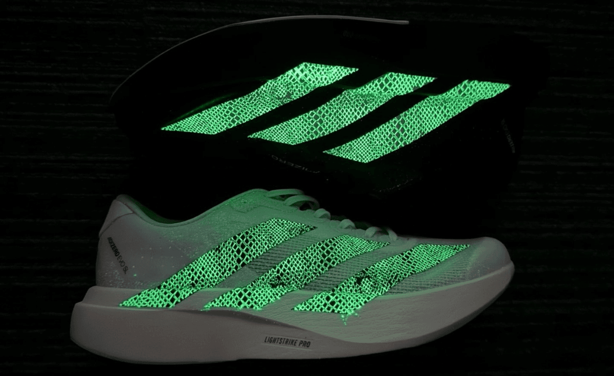 Two colorways of the atmos x adidas Adizero Evo SL G-SNK Pack in black and white, featuring glow-in-the-dark snakeskin accents on the upper and Lightstrike Pro midsole