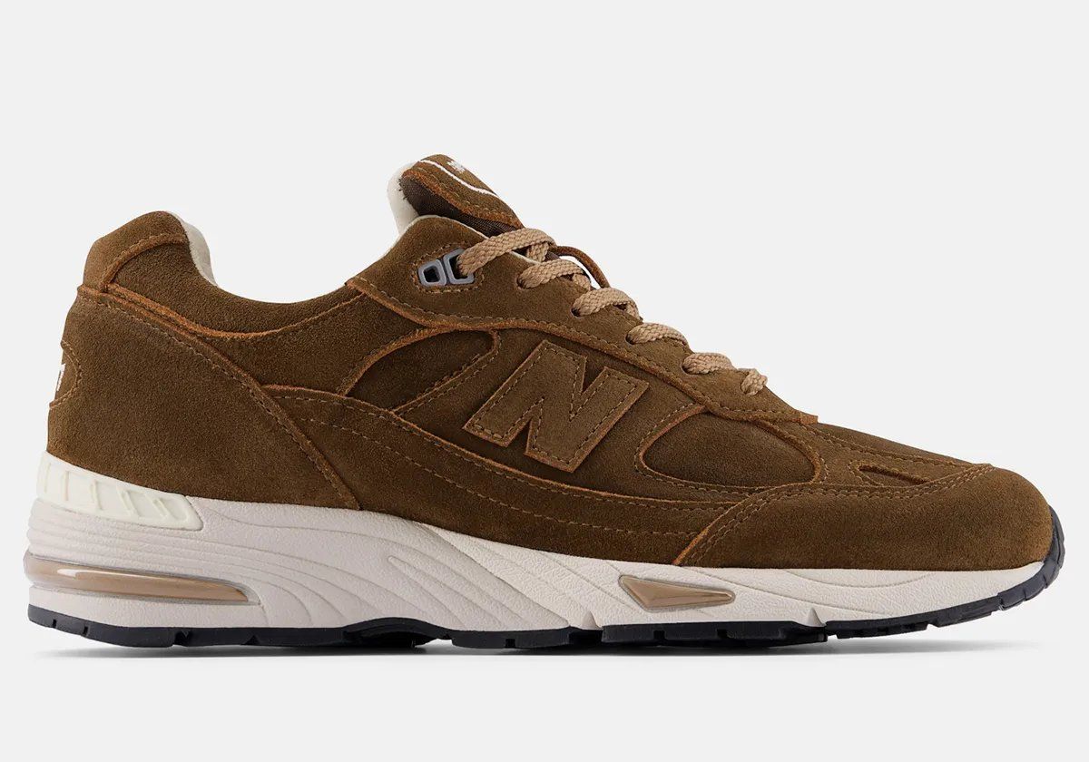 New Balance 991v1 in Coffee Suede colorway featuring premium pig suede upper with earthy brown tones and white/black sole unit