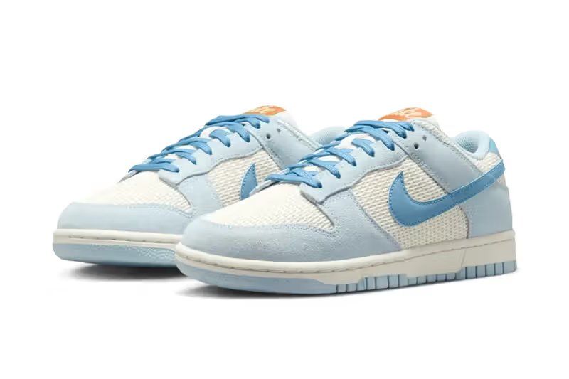 Nike Women's Dunk Low SE in Sail and Hydrogen Blue colorway, showcasing cream leather uppers with soft blue accents and work blue heel detailing