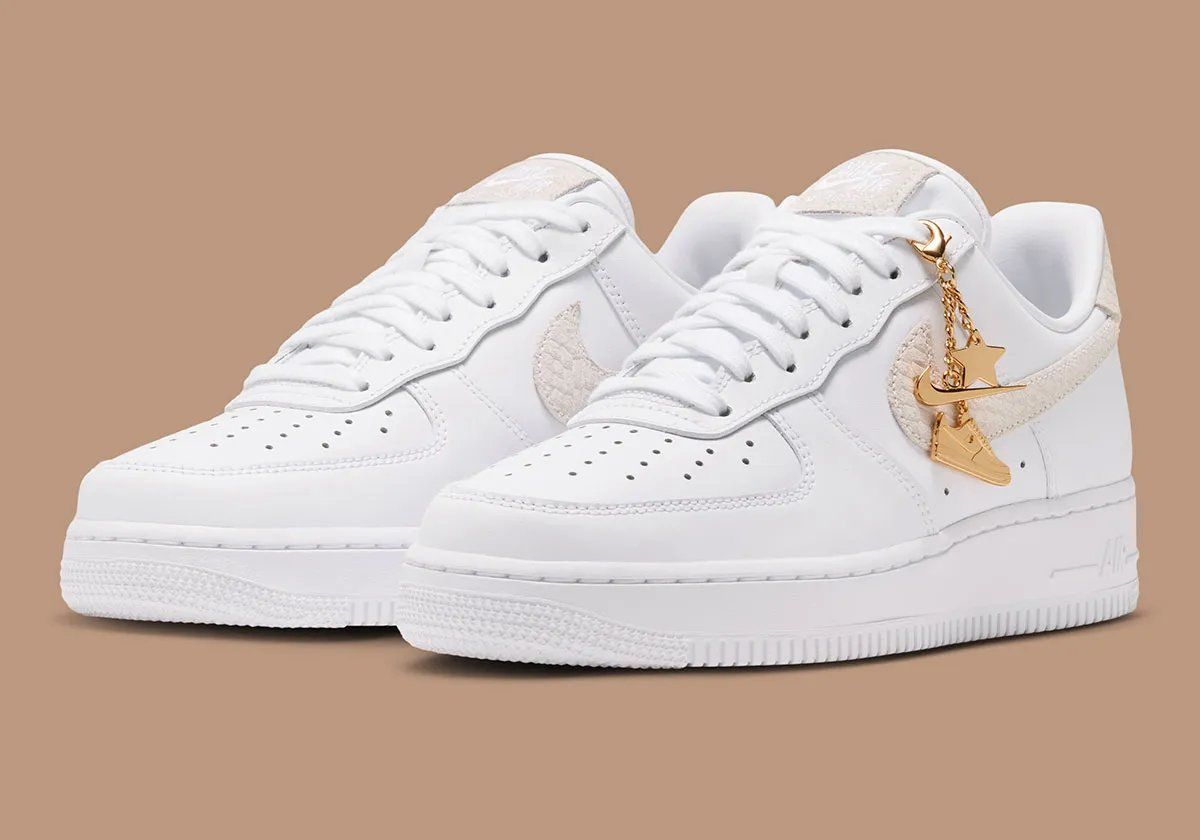 Women's Nike Air Force 1 Low in white leather with tan snakeskin Swoosh and detachable golden charm accessories