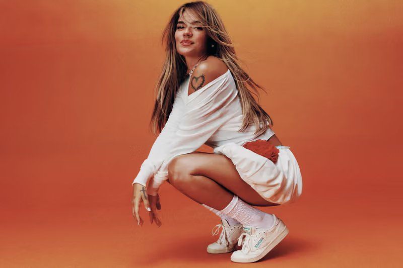 Karol G wearing Reebok Classics in the 'Born Classic. Worn Together.' campaign, shot in Mexico City with warm sunset tones reflecting her Tropicoqueta era