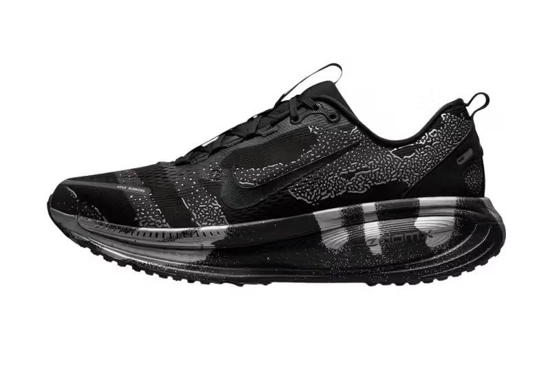 Nike Vomero 18 DSRPT in Iron Grey, Light Smoke Grey, and Black colorway showing abstract two-tone design on running shoe upper