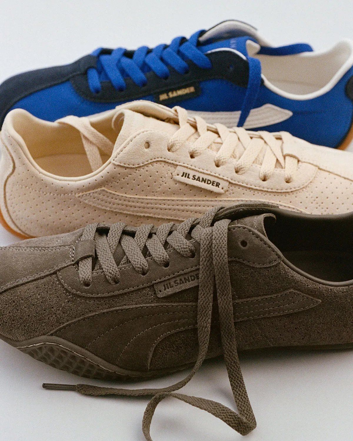 PUMA x Jil Sander K-Street sneaker in blue and navy colorway, showing low-profile sole and layered panel construction
