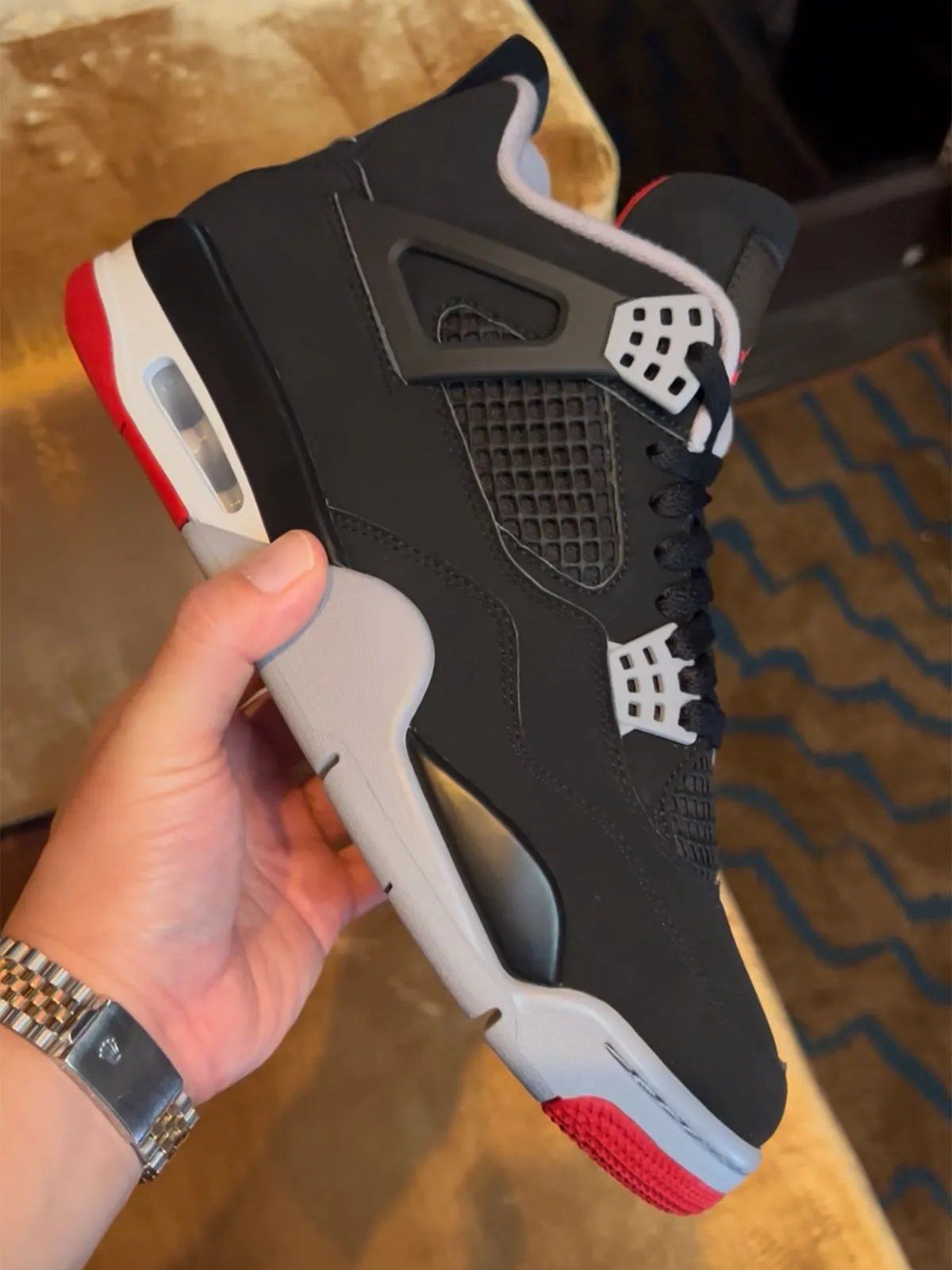 Air Jordan 4 Bred retro sneaker featuring black, grey, red, and white colorway from Jordan Brand's Holiday 2026 collection preview at New York Fashion Week