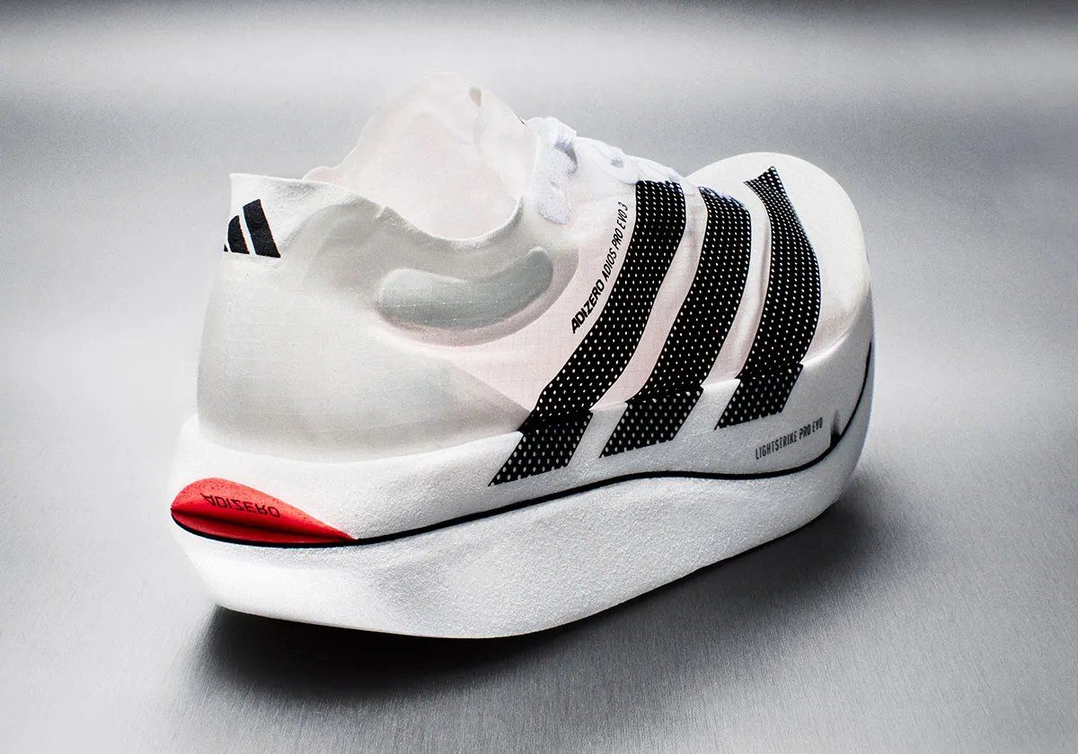 adidas Adizero Adios Pro EVO 3 running shoe in white and grey colorway, side profile view showing lightweight construction