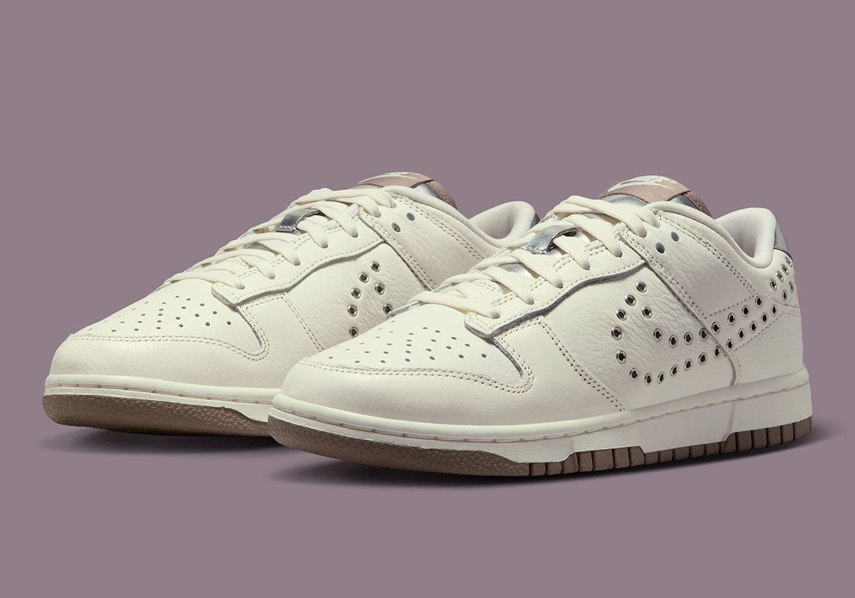 Nike Dunk Low women's sneaker featuring perforated metal Swoosh design in Sail leather with Metallic Silver and Mink Brown accents