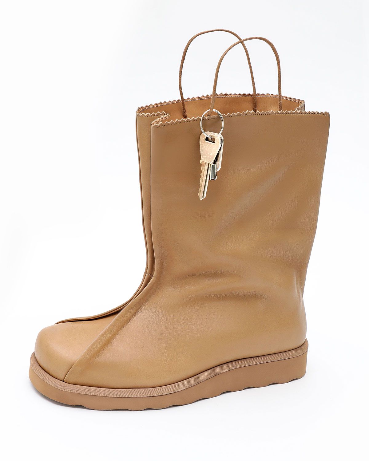 Esenes Bag Boot in brown paper leather, designed in collaboration with artist Gab Bois, featuring serrated edges and handle pull-tabs inspired by a grocery bag