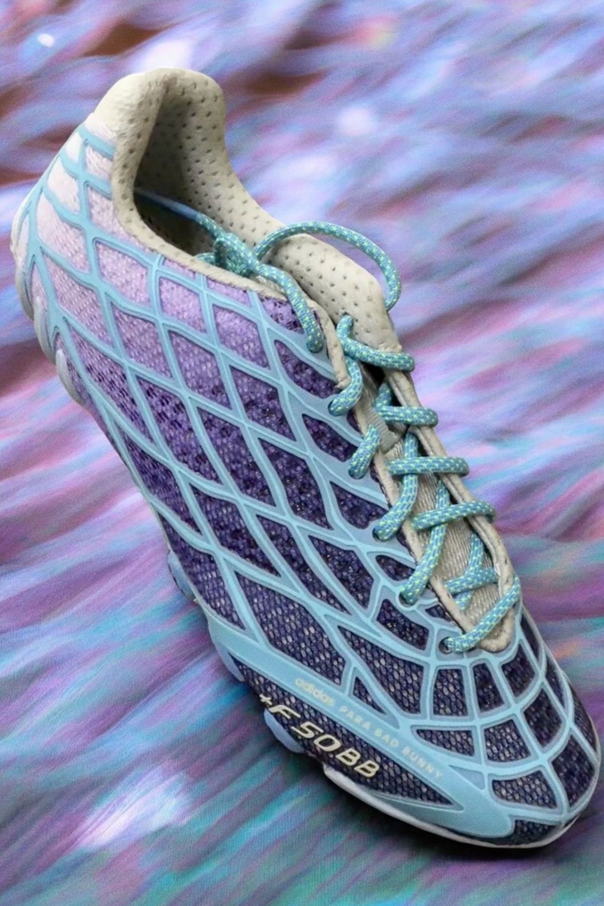 Bad Bunny x adidas F50 Ghost Sprint in purple and blue gradient colorway, showing F50 TPU skeletal upper paired with Ghost Sprint track outsole