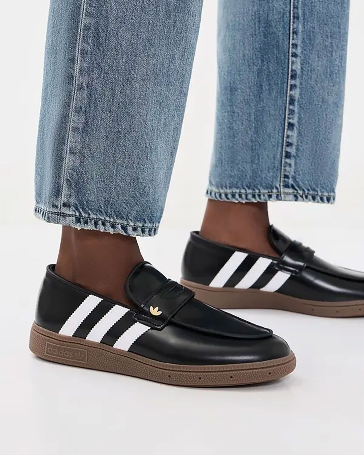 adidas Handball Spezial Loafer in black leather with white accents and gum rubber sole, showcasing refined buckle tongue and thinned collar construction