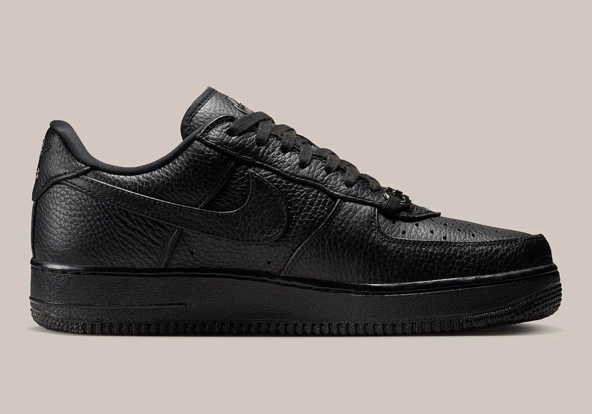 Nike Air Force 1 Low in black pebbled leather featuring silver loafer buckle accent at lace collar - detail view 3