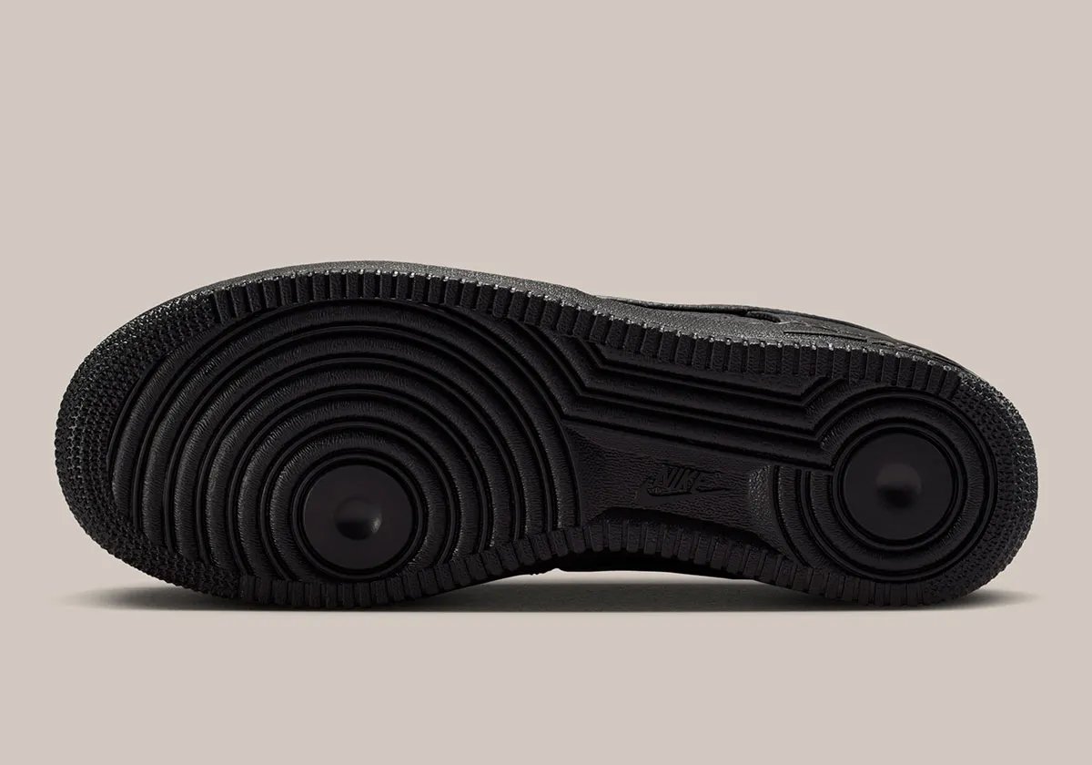 Nike Air Force 1 Low in black pebbled leather featuring silver loafer buckle accent at lace collar - detail view 2