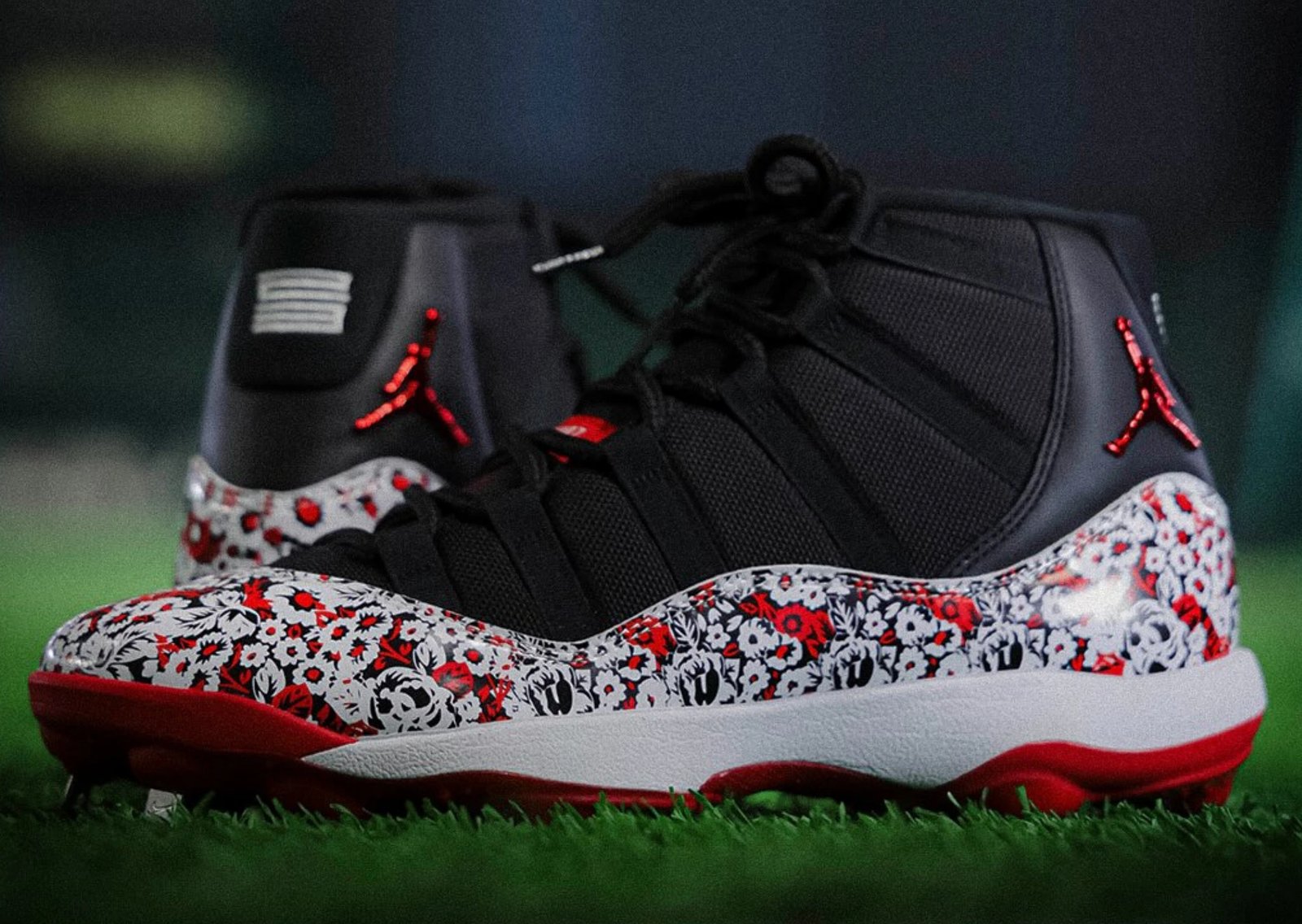 Yomiuri Giants Air Jordan 11 PE cleat featuring black upper with red and white floral print, red cleat plate, and metallic red Jumpman branding - detail view 1