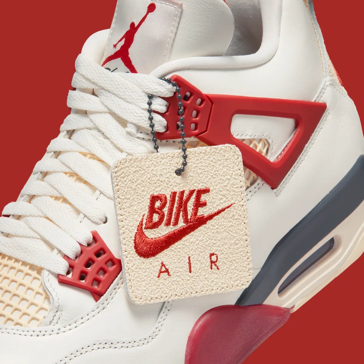 Nigel Sylvester x Air Jordan 4 'Brick After Brick' in Sail, Anthracite, Muslin and Cinnabar colorway, side view showing mesh paneling and flight wings detail - detail view 2