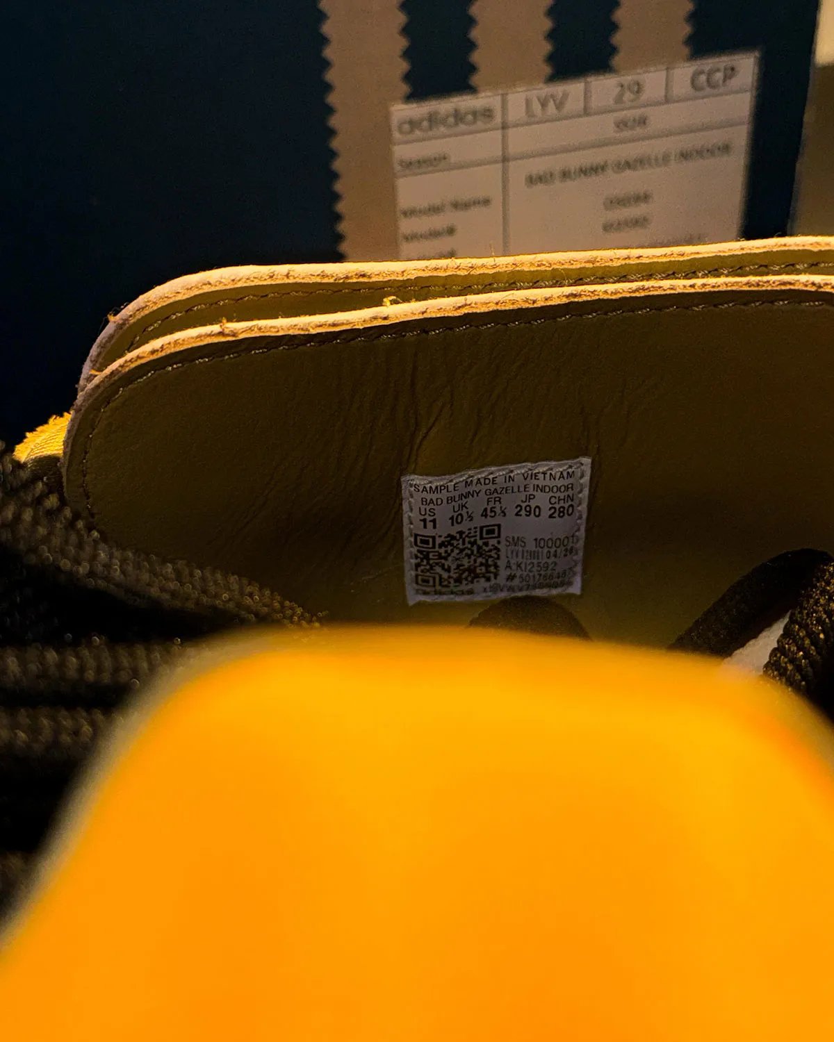 Bad Bunny x adidas Gazelle Indoor in Solar Gold with black stripes, showing canvas foxing and offset T-toe construction - detail view 1