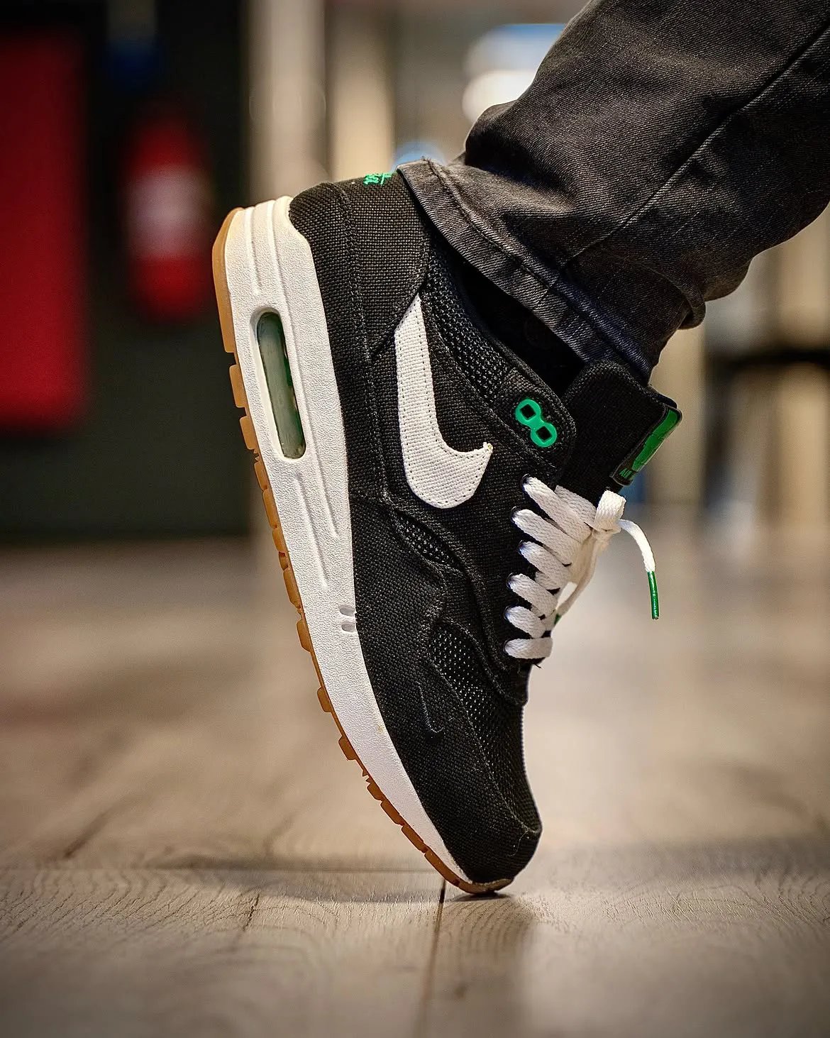 Patta x Nike Air Max 1 Lucky Green in black denim with bright green accents on eyelets and heel branding - detail view 2