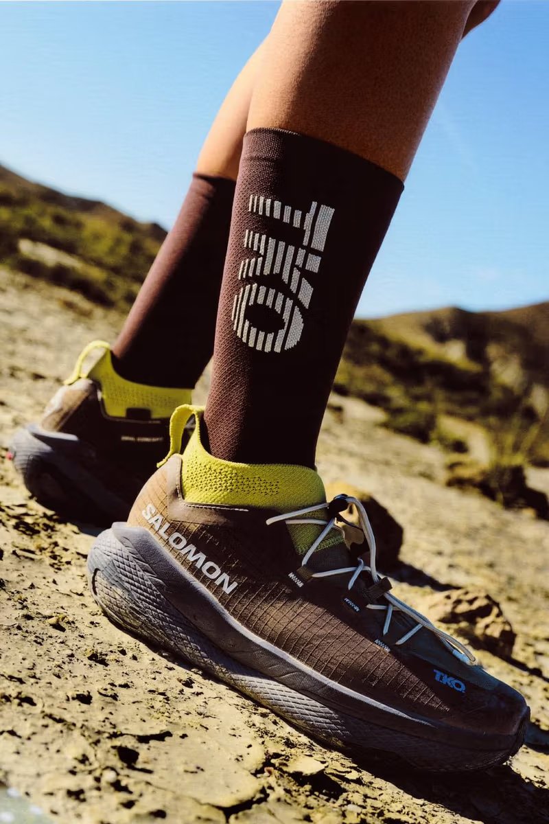 Salomon x Pas Normal Studios GRVL Concept hybrid training shoe with PEBA supercritical foam midsole and carbon blade construction, displayed with RACE SKIN 2 running vest from the T.K.O. SS26 collection - detail view 1