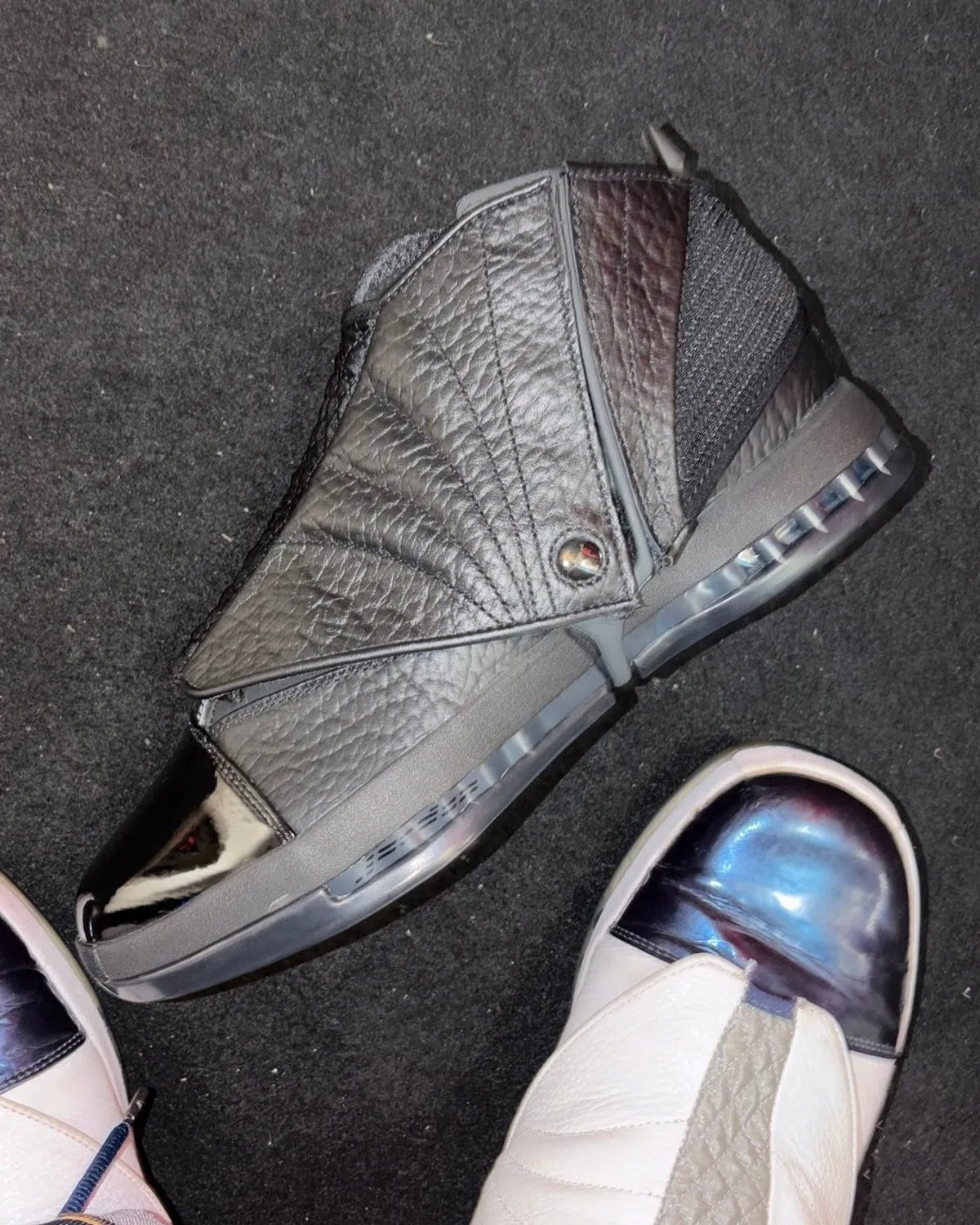 Air Jordan 16 Black Pack featuring full-grain pebbled leather upper and glossy patent leather toe box in all-black colorway - detail view 1