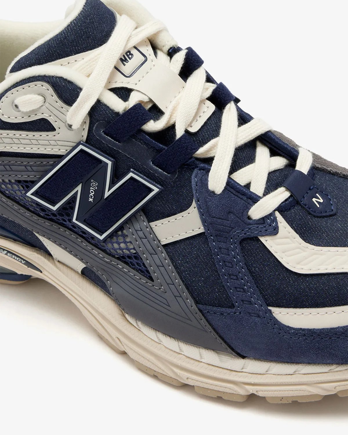 New Balance 1906U in navy and off-white colorway, showing side profile of the lifestyle sneaker - detail view 3