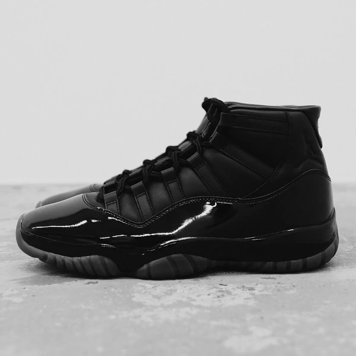 Comme des Garçons Homme Plus x Air Jordan 11 black and white colorways featuring premium cowhide leather and patent leather construction - detail view 2