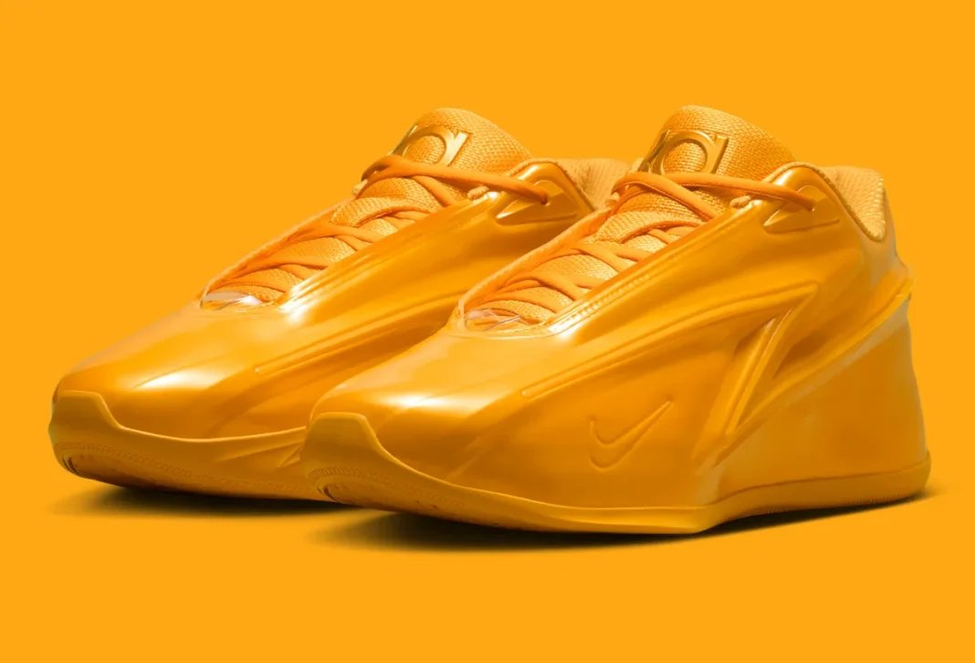 Nike KD 19 'Butter Candy' in solar flare golden-yellow, showing the full lateral silhouette with molded side panels and exaggerated heel platform - detail view 1