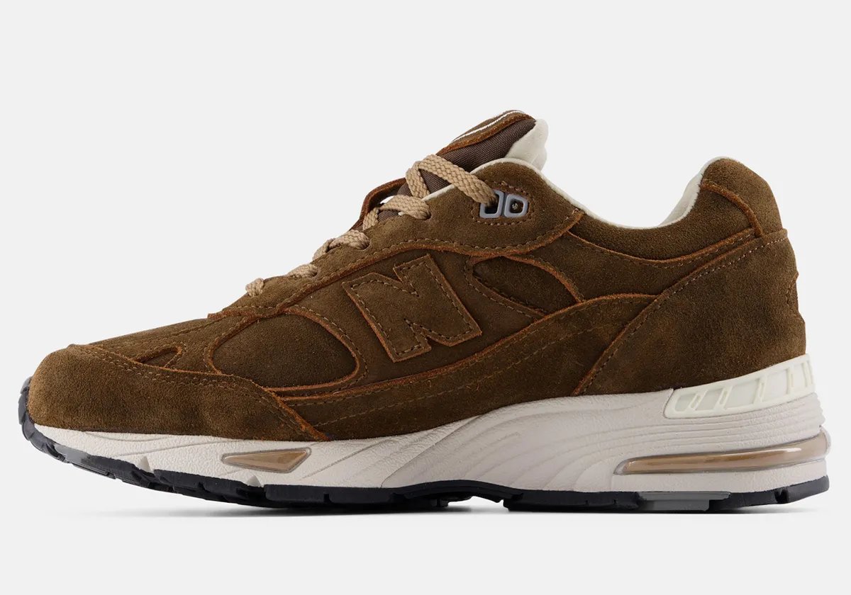 New Balance 991v1 in Coffee Suede colorway featuring premium pig suede upper with earthy brown tones and white/black sole unit - detail view 1