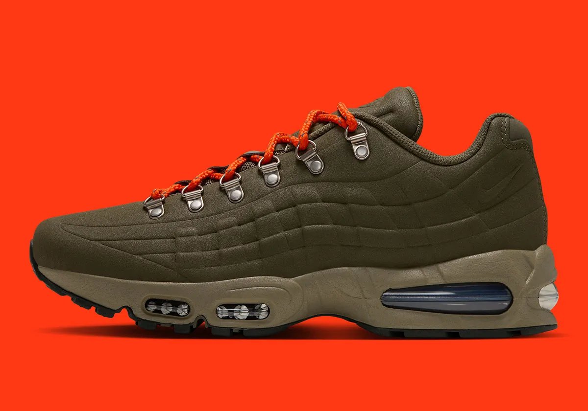 Nike Air Max 95 I-95 in Medium Olive with orange laces, showing molded shell construction and metal d-ring eyelets - detail view 1