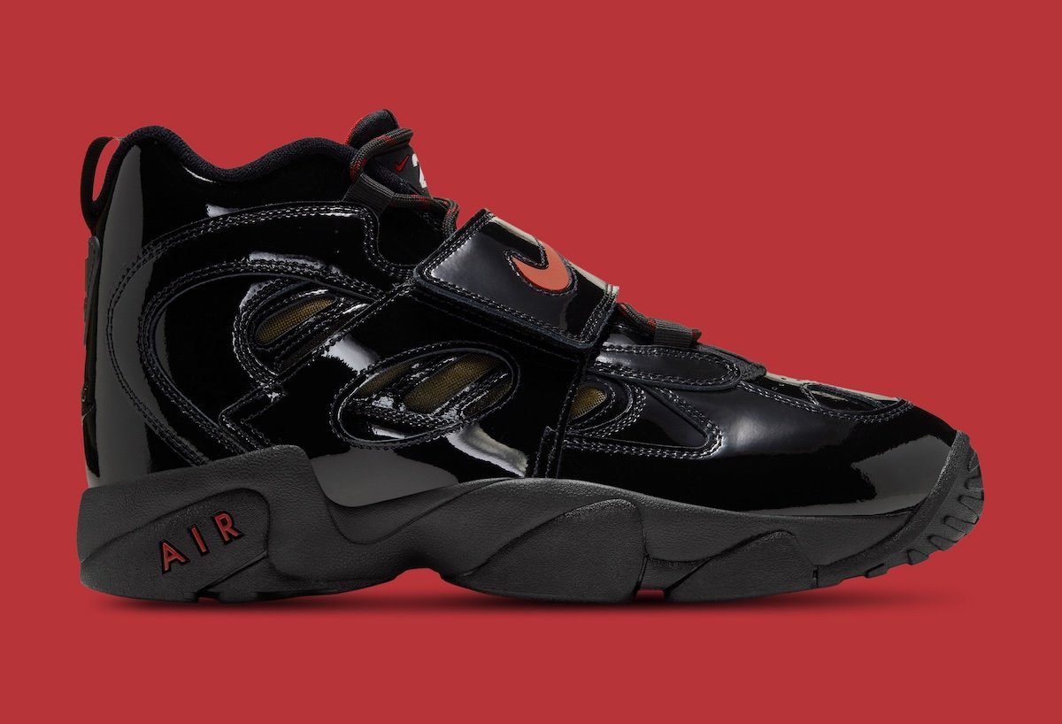 Nike Air Diamond Turf 2 in Patent Black with Gym Red and Metallic Gold accents, shown from lateral side view highlighting the glossy patent leather upper and midfoot strap - detail view 3