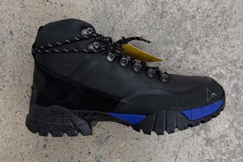 ROA x fragment design Andreas Boot side profile showing leather upper, Vibram sole, and metallic lace hooks - detail view 3