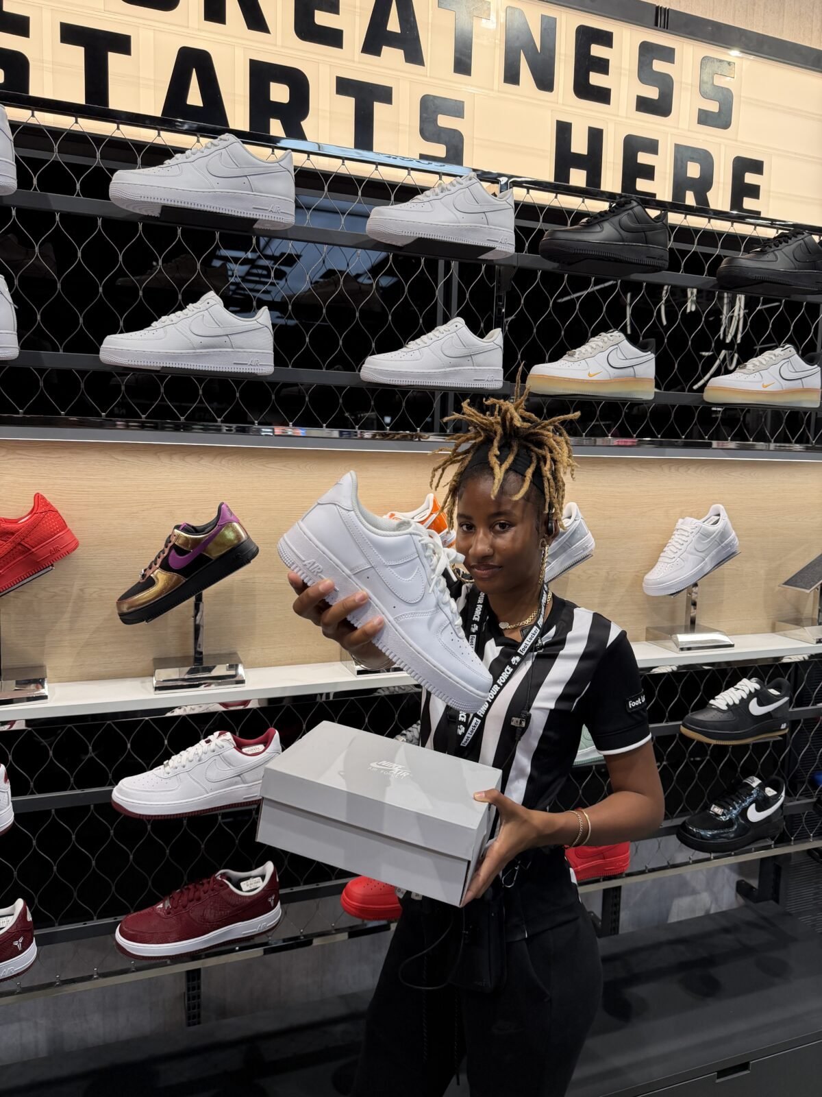 Nike Air Force 1 displayed in Foot Locker retail setting with employee engagement - detail view 2