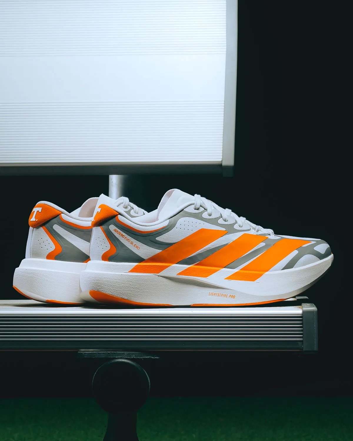 adidas EVO SL EXO in Tennessee colorway featuring white base, metallic silver exoskeleton, and orange Three Stripes with Volunteers branding - detail view 4