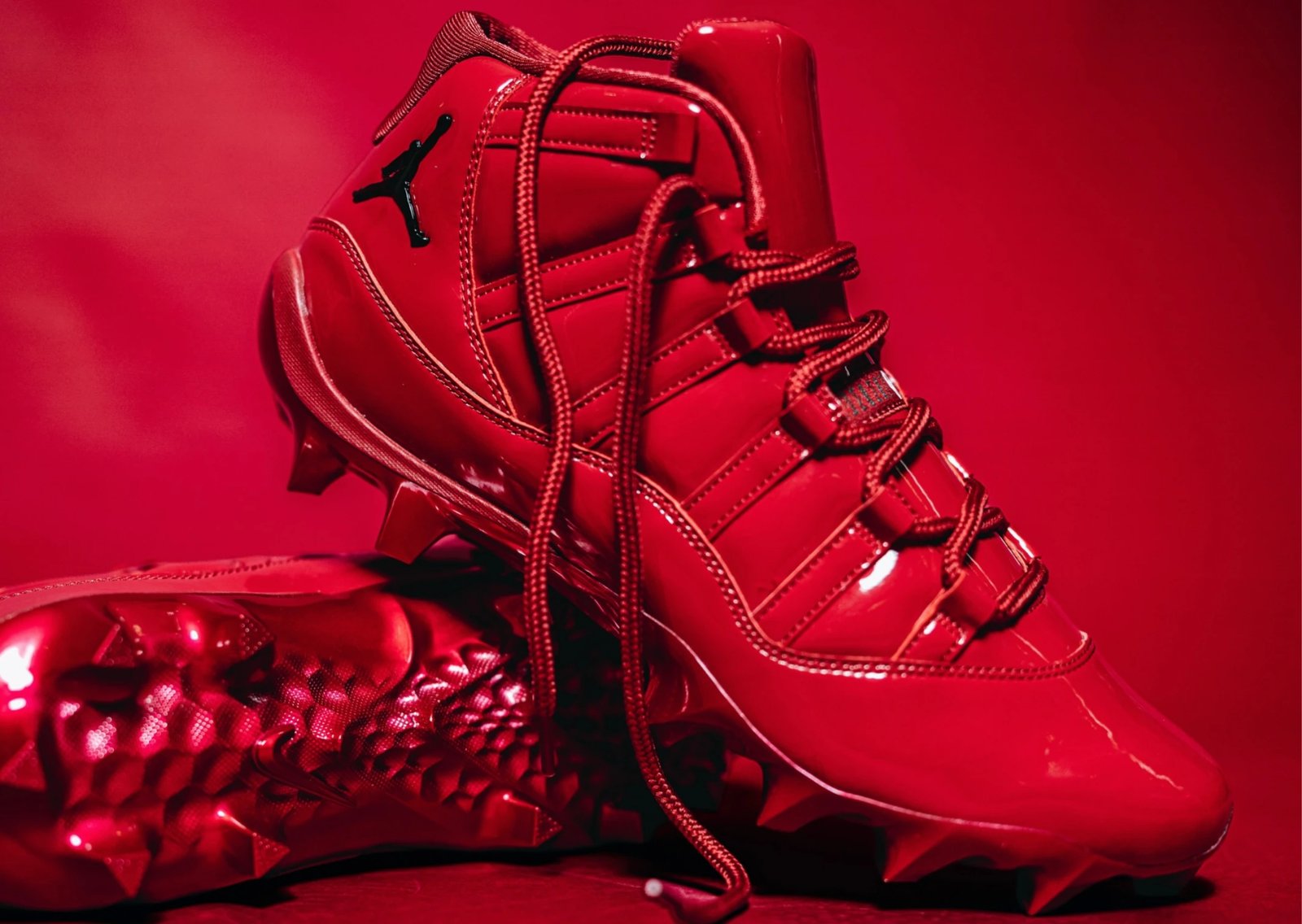 Air Jordan 11 Oklahoma PE in monochrome Sooner red patent leather with metallic red spikes and white OU logo on tongue - detail view 1