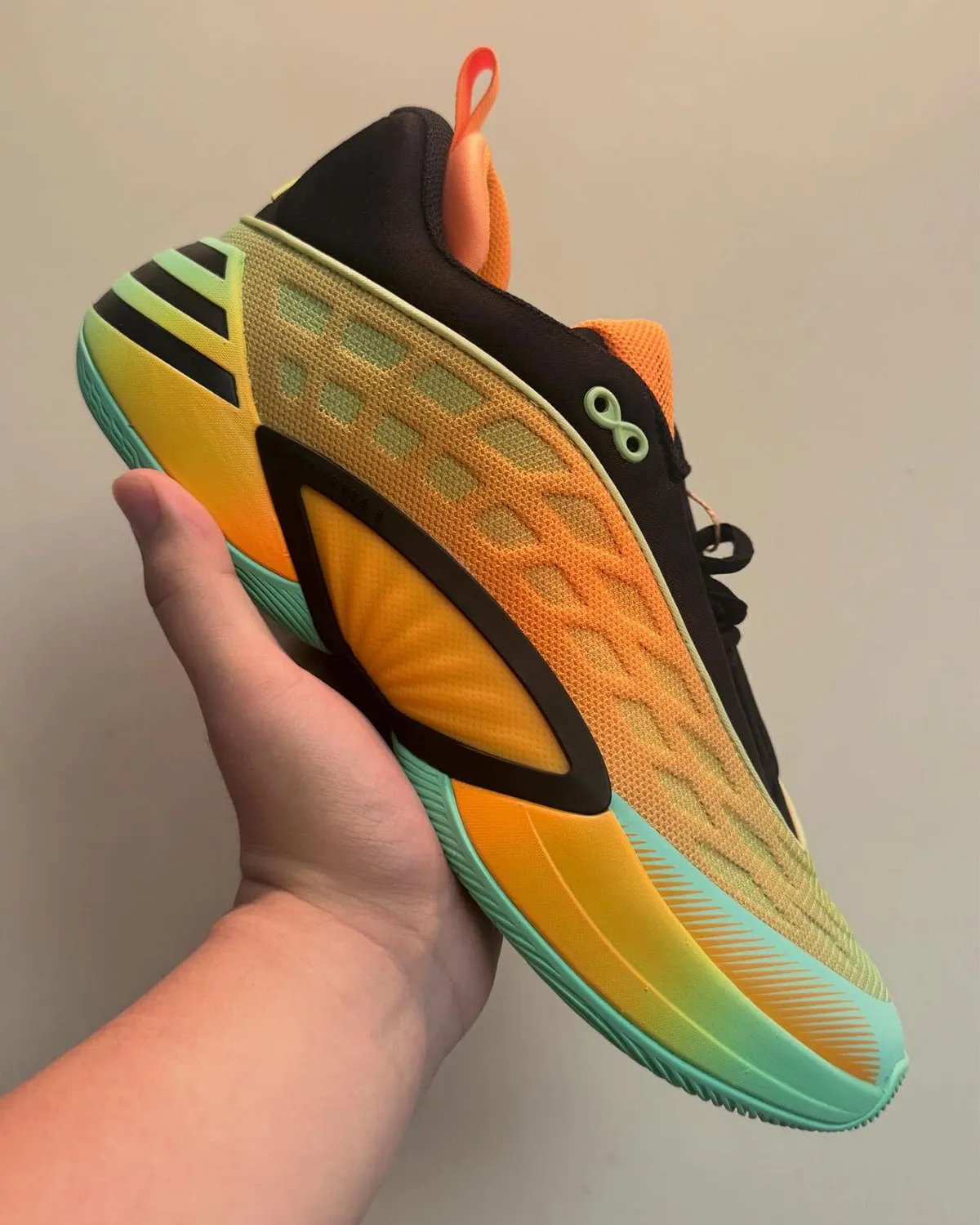 adidas D.O.N. Issue 8 in Lucid Tangerine, Core Black, and Pulse Mint colorway showing low-cut silhouette with webbed overlay system - detail view 1