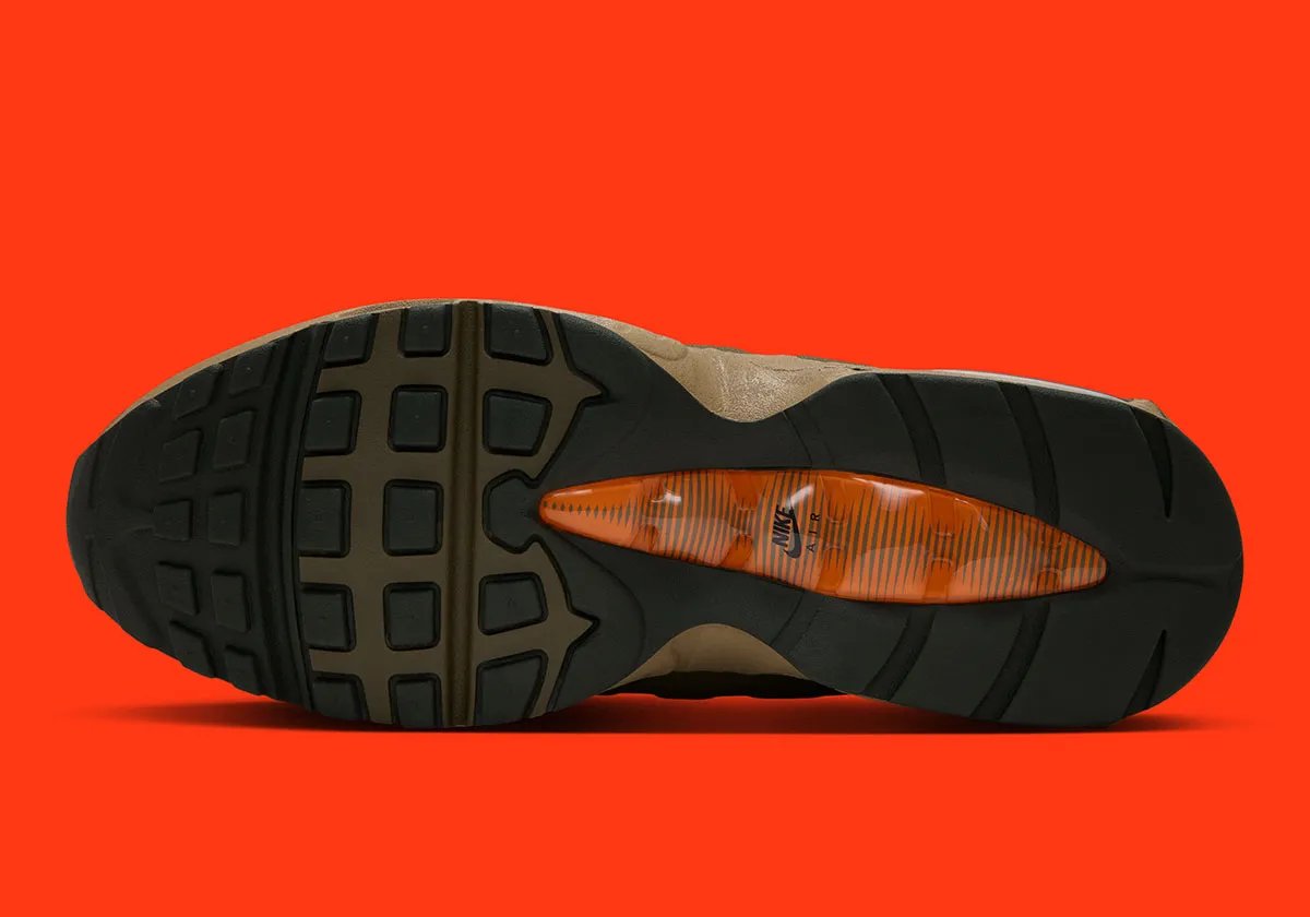 Nike Air Max 95 I-95 in Medium Olive with orange laces, showing molded shell construction and metal d-ring eyelets - detail view 2