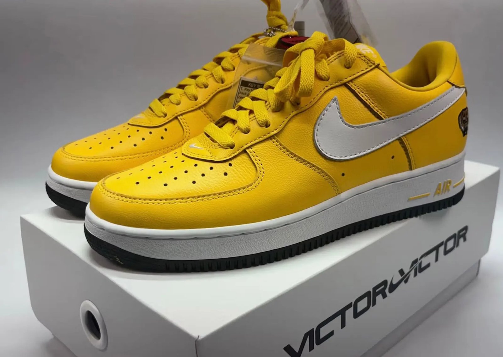 Victor Victor x Nike Air Force 1 Low '01 in Yellow and University Red, featuring monochrome plush leather with white Swoosh and custom dog head logo on lateral heel - detail view 3