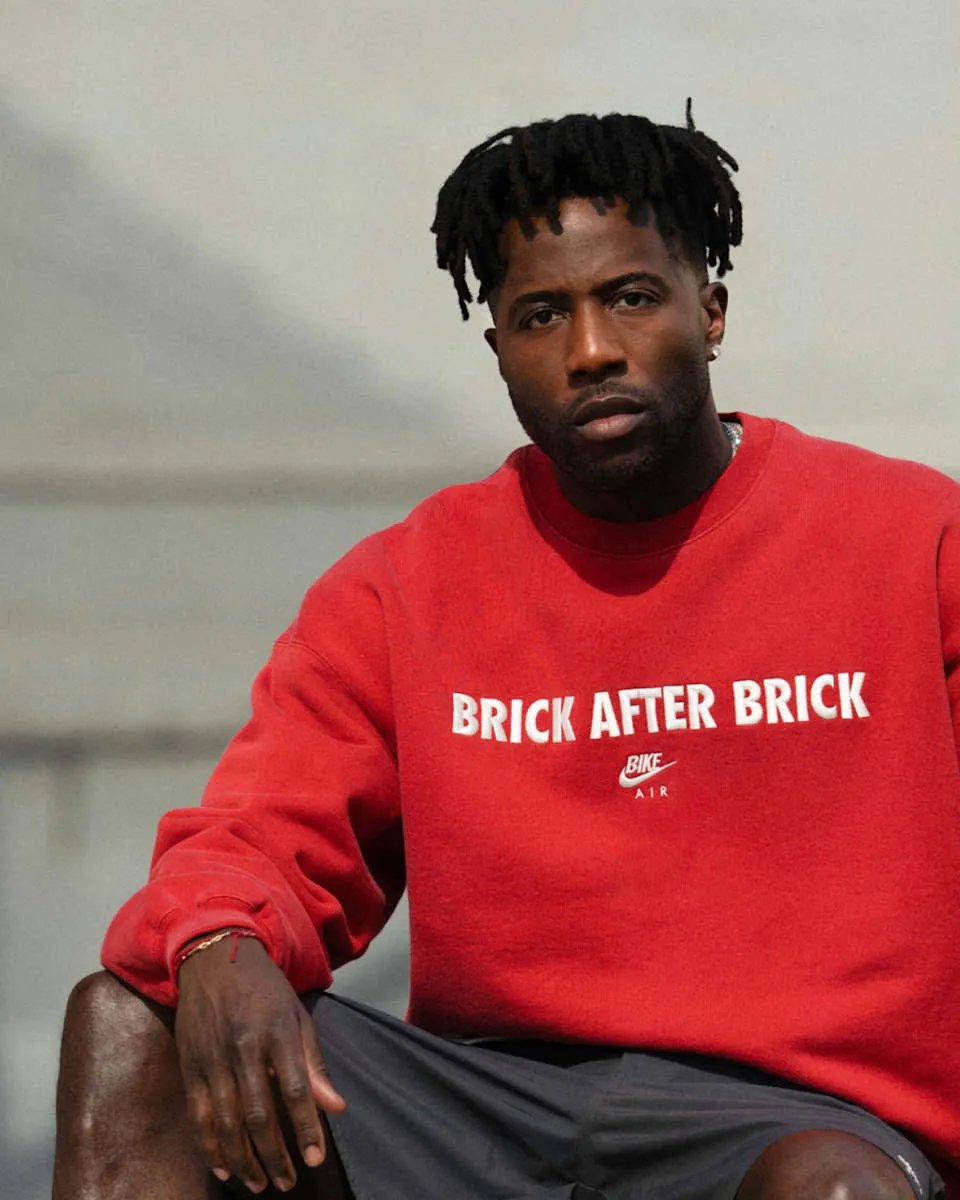 Nigel Sylvester x Air Jordan 4 'Brick After Brick' in Sail, Anthracite, Muslin and Cinnabar colorway, side view showing mesh paneling and flight wings detail - detail view 3