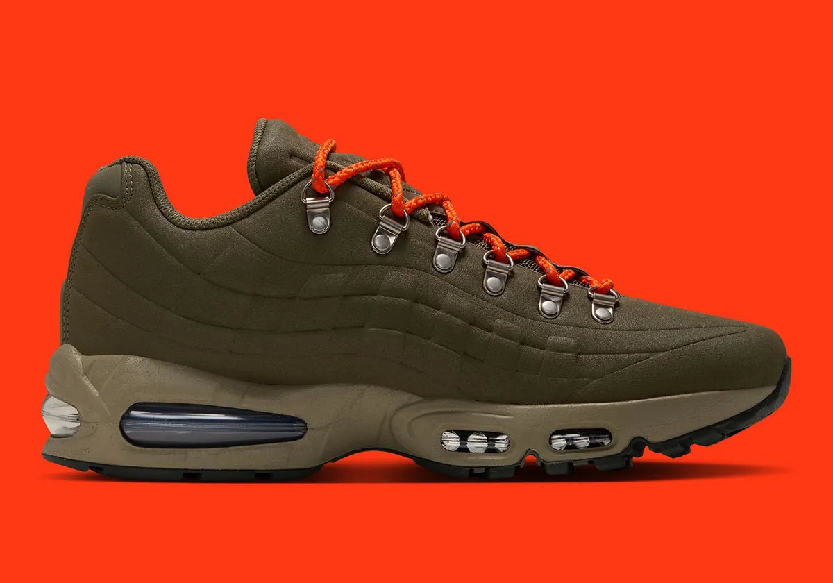 Nike Air Max 95 I-95 in Medium Olive with orange laces, showing molded shell construction and metal d-ring eyelets - detail view 3